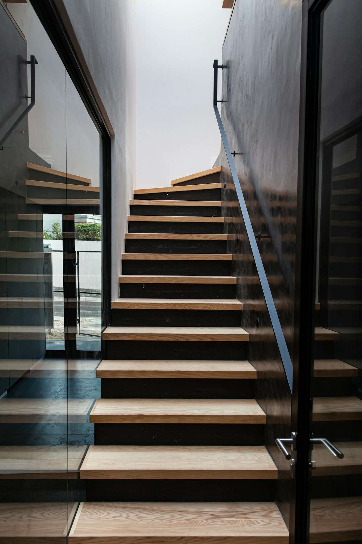 Escada de madeira com guarda-corpo de vidro em casa moderna